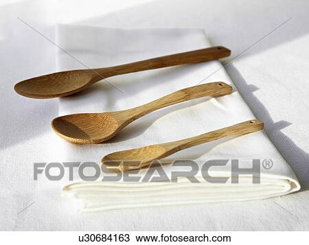 Stock Image - Wooden spoons on folded napkin. Fotosearch