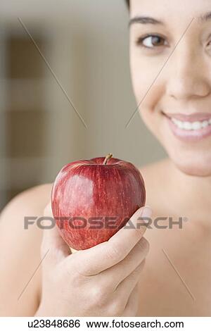 Attractive woman holding apple View Large Photo Image Stock Photograph - Attractive woman holding apple. Fotosearch