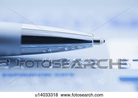 Stock Photo - Ballpoint pen on credit card, studio shot. Fotosearch