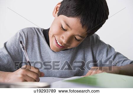 Stock Photo - Boy (10-11) doing homework. Fotosearch