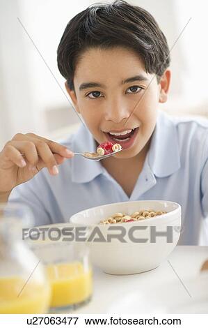 Boy (12-13) having cereals for breakfast View Large Photo Image Stock Photo - Boy (12-13) having cereals for breakfast. Fotosearch