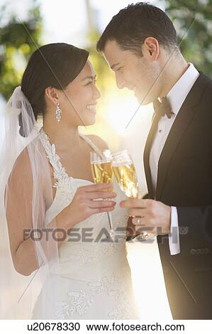 Stock Image - Bride and groom toasting with champagne. Fotosearch