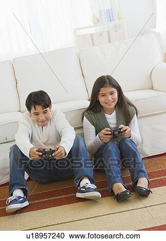 Brother (12-13) and sister (10-11) playing video games View Large Photo Image Stock Image - Brother (12-13) and sister (10-11) playing video games. Fotosearch