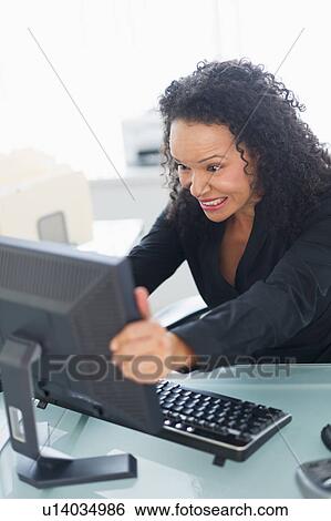 Stock Photograph - Business woman shaking computer monitor. Fotosearch