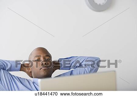 Stock Image - Businessman relaxing in office. Fotosearch