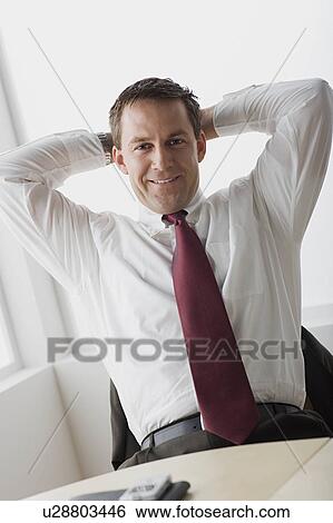 Stock Photograph - Businessman relaxing in office. Fotosearch