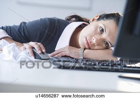 Businesswoman in front of computer, looking tired View Large Photo Image Stock Photo - Businesswoman in front of computer, looking tired. Fotosearch