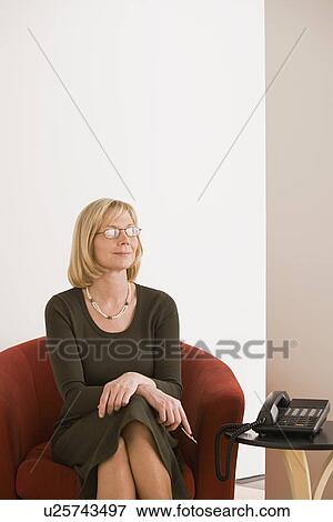 Stock Photo - Businesswoman sitting in armchair. Fotosearch