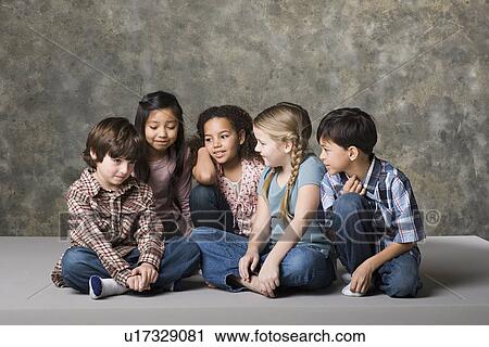Stock Image - Children (6-7, 8-9) comforting fiend, studio shot. Fotosearch