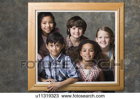 Stock Image - Children (6-7, 8-9) posing together in frame, studio shot. Fotosearch