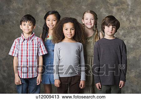 Stock Image - Children (6-7, 8-9) posing together, studio shot. Fotosearch