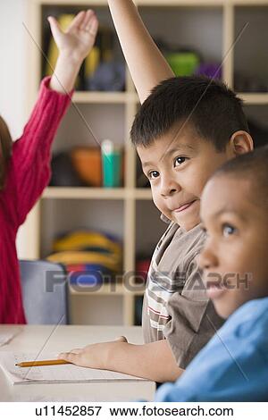 Children (6-7) raising hands in classroom View Large Photo Image Stock Photo - Children (6-7) raising hands in classroom. Fotosearch