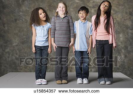 Children (8-9) making faces, studio shot View Large Photo Image Stock Photo - Children (8-9) making faces, studio shot. Fotosearch