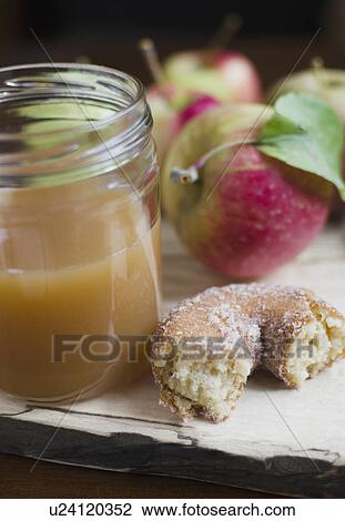 Stock Image - Close up apple cider, donut and apple on table. Fotosearch