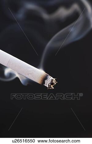 Close up of burning cigarette on black background View Large Photo Image Stock Image - Close up of burning cigarette on black background. Fotosearch
