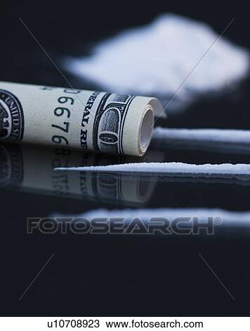 Stock Image - Close up of cocaine and rolled up banknote on black background. Fotosearch