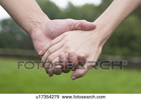 Close-up of couple holding hands View Large Photo Image Stock Photo - Close-up of couple holding hands. Fotosearch