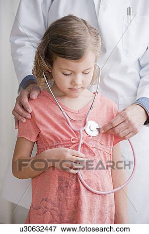 Close up of doctor and girl (4-5) listening to stethoscope View Large Photo Image Stock Photo - Close up of doctor and girl (4-5) listening to stethoscope. Fotosearch