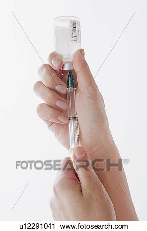 Close up of doctor's hand preparing syringe for injection View Large Photo Image Stock Image - Close up of doctor's hand preparing syringe for injection. Fotosearch