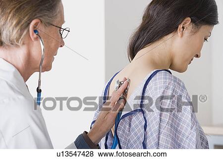 Close up of female doctor examining patient with stethoscope View Large Photo Image Stock Photo - Close up of female doctor examining patient with stethoscope. Fotosearch