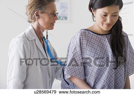 Close up of female doctor examining patient with stethoscope View Large Photo Image Stock Photo - Close up of female doctor examining patient with stethoscope. Fotosearch