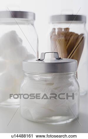 Stock Image - Close up of gauze and spatulas in jars studio shot. Fotosearch