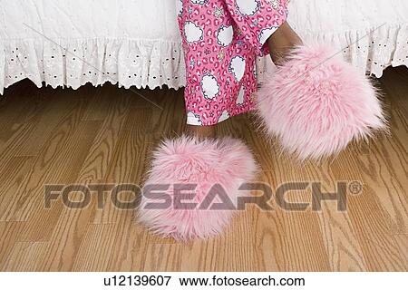 Stock Photo - Close up of girl's (10-11) legs in pajamas and slippers. Fotosearch