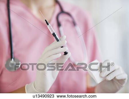 Close up of hands of female nurse holding syringe and gaze View Large Photo Image Stock Image - Close up of hands of female nurse holding syringe and gaze. Fotosearch