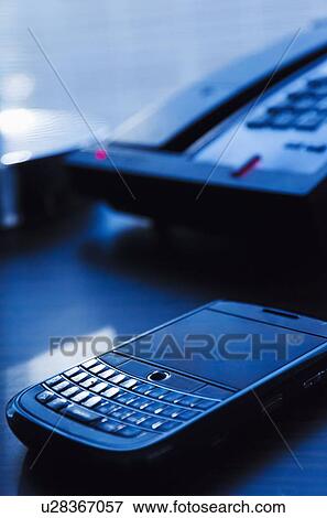 Close-up of mobile phone on desk View Large Photo Image Stock Photo - Close-up of mobile phone on desk. Fotosearch