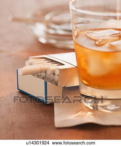Close up of open cigarette pack and alcohol drink in glass View Large Photo Image Picture - Close up of open cigarette pack and alcohol drink in glass. Fotosearch