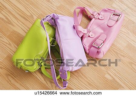 Close up of three colorful purses on parquet floor View Large Photo Image Picture - Close up of three colorful purses on parquet floor. Fotosearch