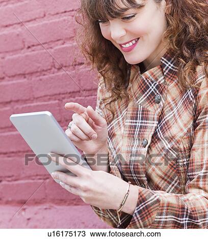 Stock Image - Close up of woman using digital tablet. Fotosearch