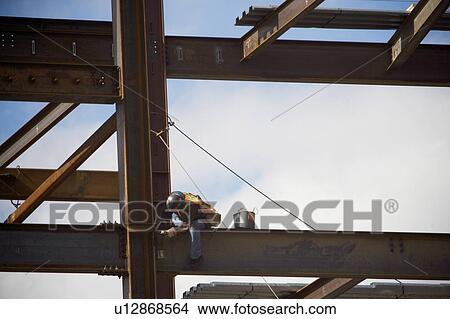 Picture - Construction worker working on unfinished structure. Fotosearch