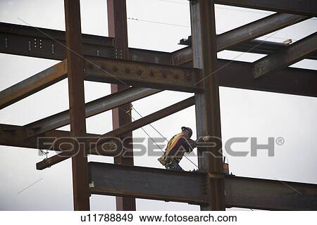 Construction worker working on unfinished structure View Large Photo Image Stock Photo - Construction worker working on unfinished structure. Fotosearch