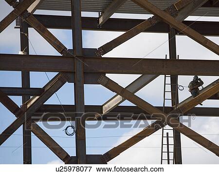 Construction worker working on unfinished structure View Large Photo Image Stock Photo - Construction worker working on unfinished structure. Fotosearch