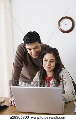 Stock Image - Couple doing paperwork at home. Fotosearch