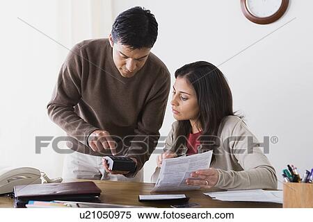 Couple doing paperwork at home View Large Photo Image Stock Photography - Couple doing paperwork at home. Fotosearch