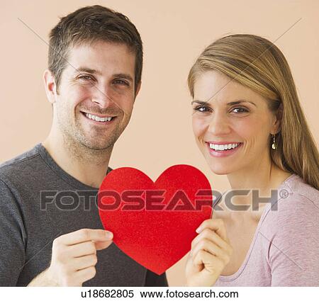 Couple holding red paper heart View Large Photo Image Stock Photography - Couple holding red paper heart. Fotosearch