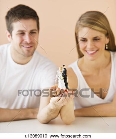 Couple holding small wedding figurine View Large Photo Image Stock Image - Couple holding small wedding figurine. Fotosearch
