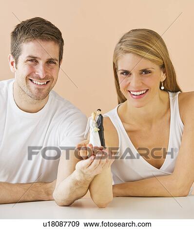 Couple holding small wedding figurine View Large Photo Image Stock Photo - Couple holding small wedding figurine. Fotosearch