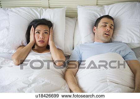 Stock Photo - Couple in bed, man snoring. Fotosearch