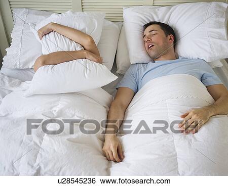 Stock Photograph - Couple in bed, man snoring. Fotosearch