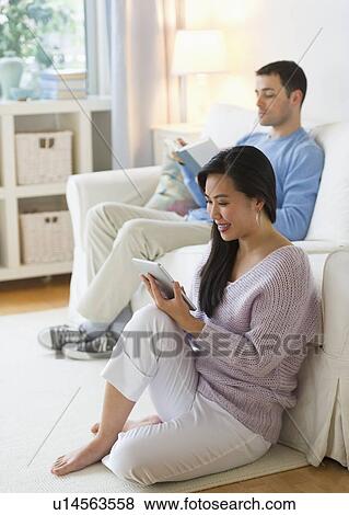 Stock Photo - Couple relaxing in living room. Fotosearch