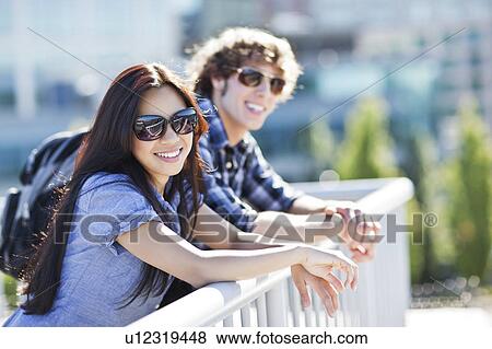 Couple standing by banister outdoors View Large Photo Image Stock Photo - Couple standing by banister outdoors. Fotosearch