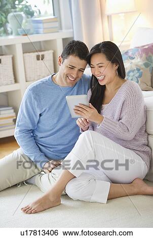 Stock Photograph - Couple using digital tablet at home. Fotosearch