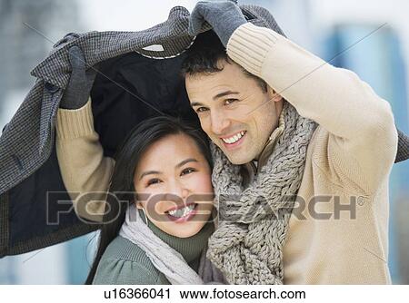 Couple walking with jacket over heads View Large Photo Image Stock Image - Couple walking with jacket over heads. Fotosearch