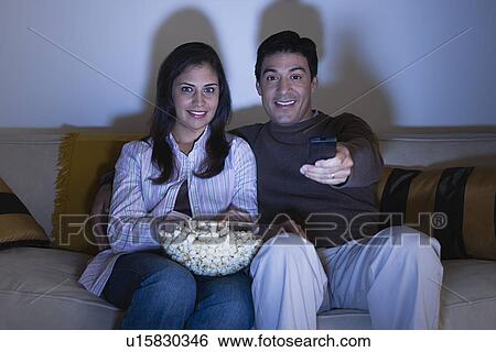 Stock Photograph - Couple watching tv on sofa. Fotosearch