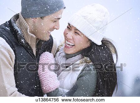 Stock Photograph - Couple wearing warm clothing having fun outside. Fotosearch