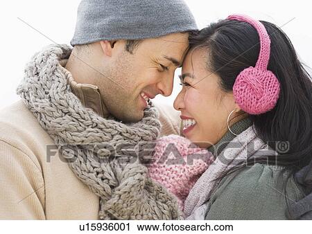 Couple wearing warm clothing looking at each other View Large Photo Image Stock Image - Couple wearing warm clothing looking at each other. Fotosearch