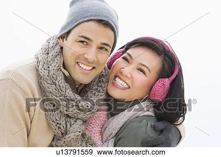 Stock Photo - Couple wearing warm clothing smiling. Fotosearch